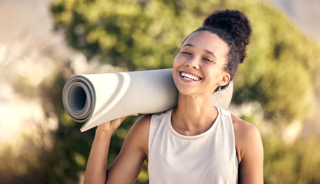 smiling woman with a yoga mat Wild Air Landing apartments in zionsville